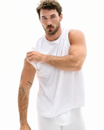 A MODEL POSES WEARING SKIMS MENS STRETCH T-SHIRT