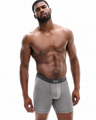 A MODEL POSES WEARING SKIMS MENS BOXERS